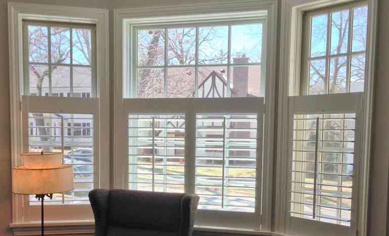 Half plantation shutters in den bay window.